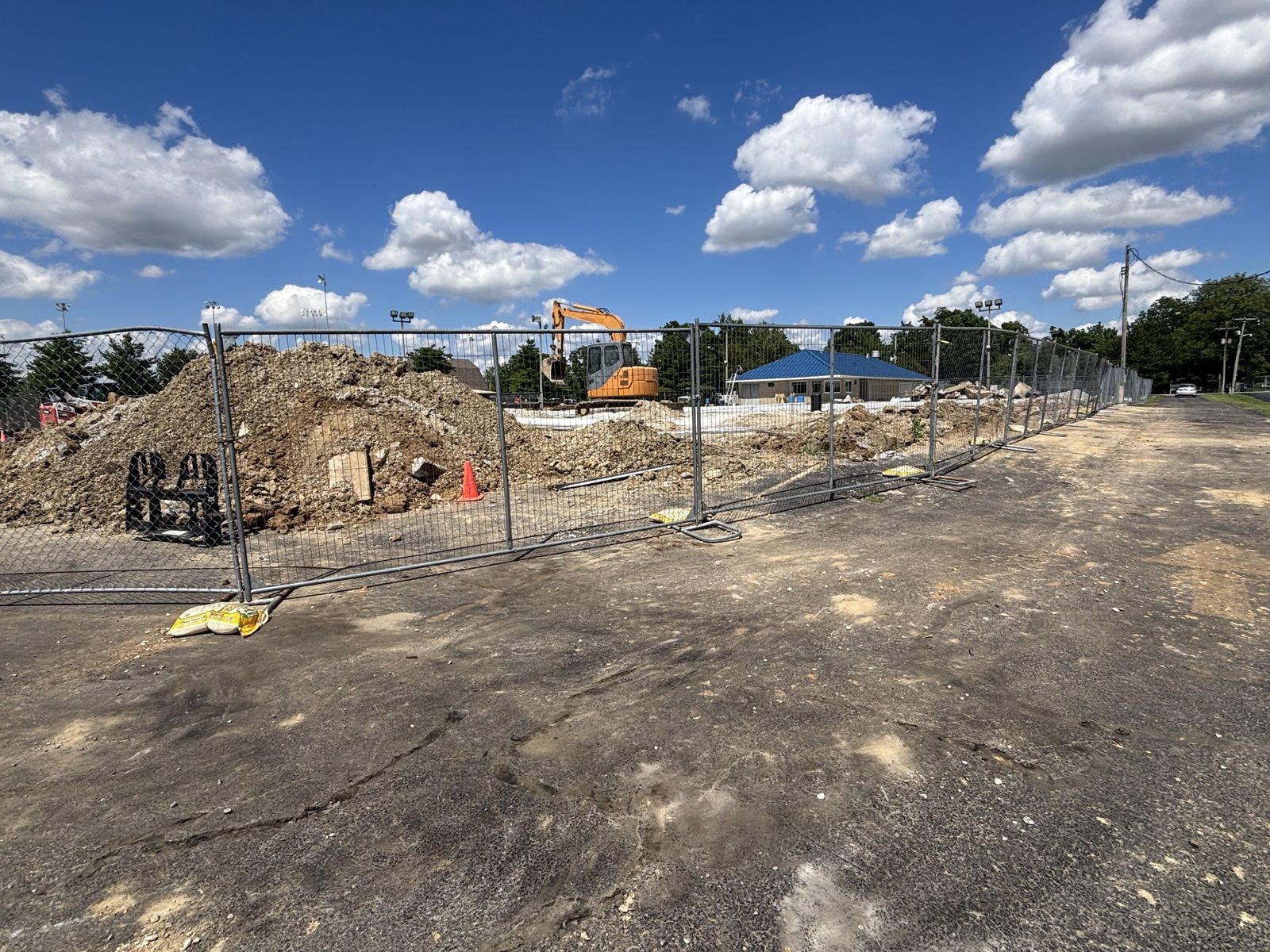 Panels around a dirt lot with an excavator working